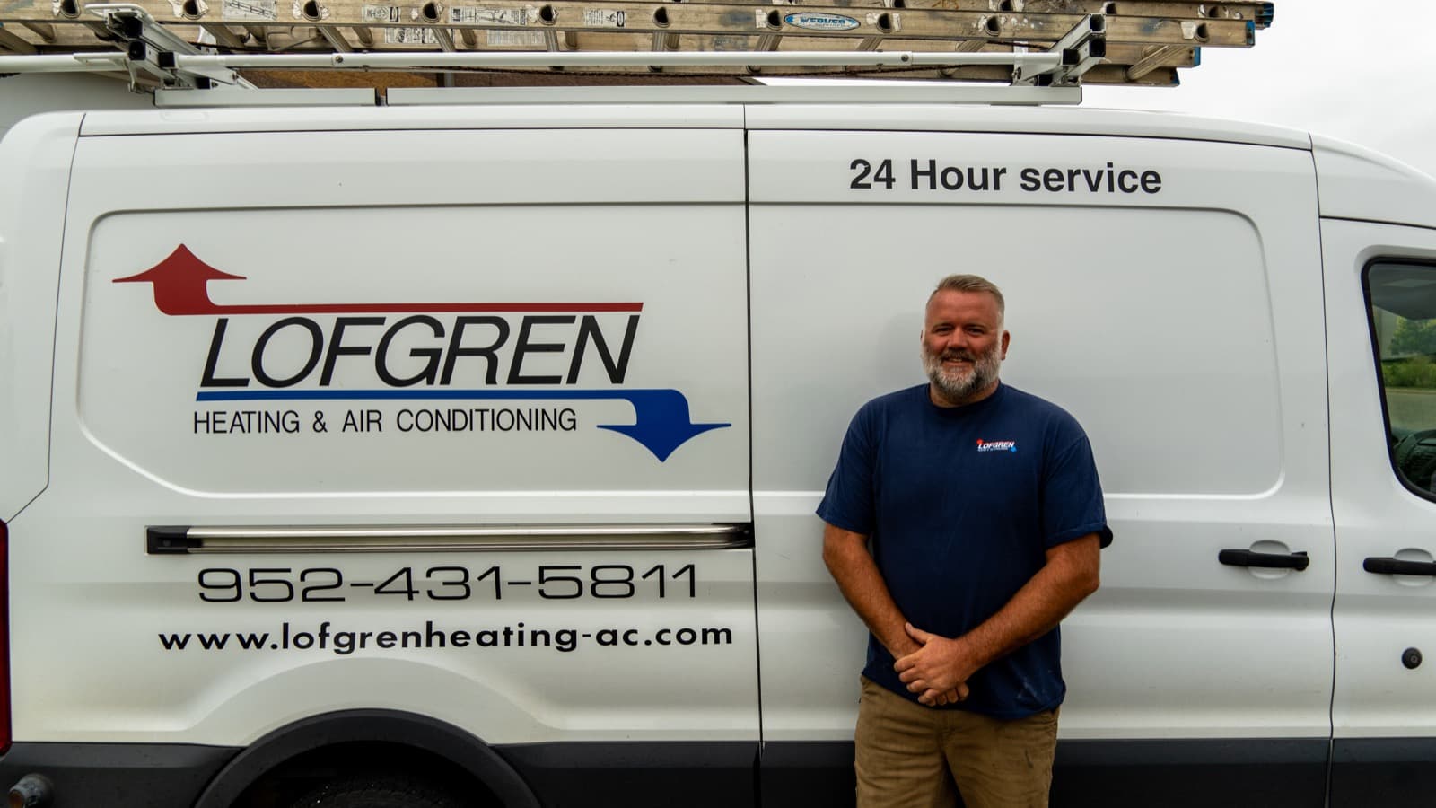 A Lofgren technician with a Lofgren Heating & Air Conditioning service van